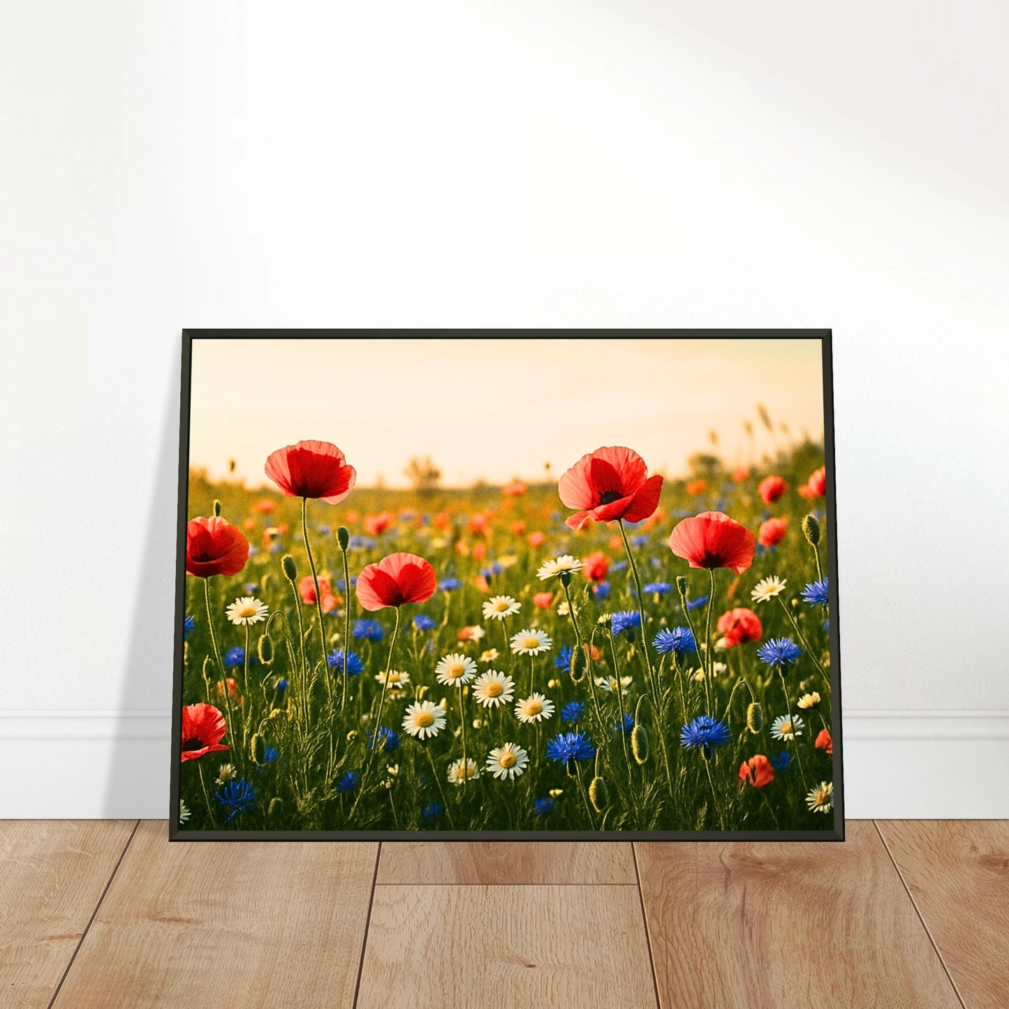 Wildflower Harmony Poster an die Wand gelehnt – strahlende Blumenwiese mit Mohn, Kornblumen und Gänseblümchen, hochwertiger Druck im schwarzen Metallrahmen.